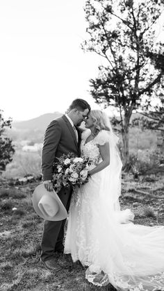 a bride and groom kissing in the field