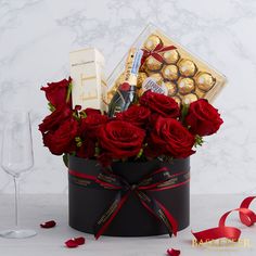 red roses in a black box with chocolates and champagne