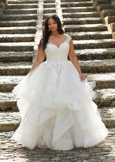 a woman in a wedding dress standing on some steps