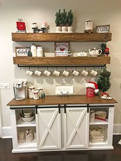 some shelves with christmas decorations on them and coffee mugs hanging from the top one