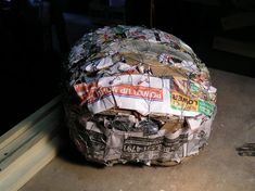 a large rock covered in newspaper sitting on the ground next to a window sill