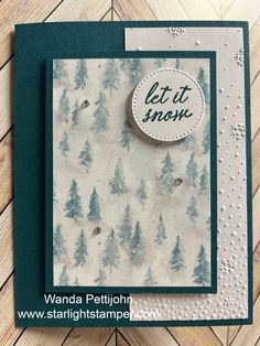 a close up of a card on a wooden surface with the words let it snow