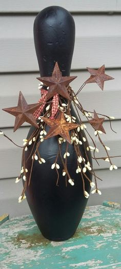 a black vase sitting on top of a green table covered in brown and white stars