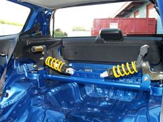 the front end of a blue car with yellow springs on it's suspensions