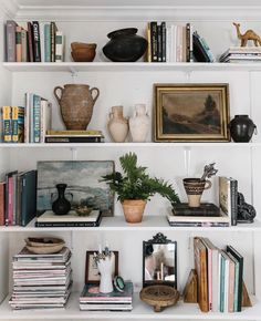 a shelf filled with lots of books and vases on top of eachother