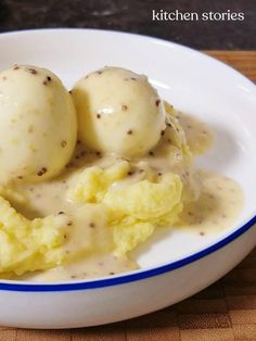 two scoops of mashed potatoes covered in gravy on a white plate