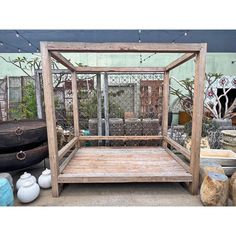 a bed made out of wood sitting on top of a wooden floor next to potted plants