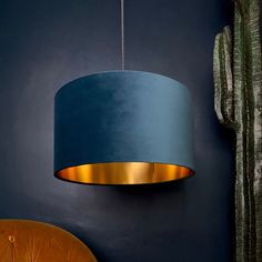 a blue lamp hanging from the ceiling next to a cactus