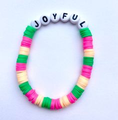 a colorful bracelet with the word joyful spelled in black letters on top of it