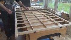 two men are working on a bed frame