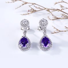 Sparkling and elegant, these purple drop earrings are perfect for that special evening out. Created in sterling silver, each drop features a pear cut stone with halo frame at its center, while additional round stones line the post settings for extra shimmer. An imaginative look you'll adore, these earrings are unsurpassed with magnificence and sparkle.Carat Weight: 3.64 ctStone Size: 6*8 mmStone Type: Jeulia® StoneNumber of Stones: 2 Stone Color: Amethyst PurpleStone Shape: PearCarat Weight: 1.1 Purple Bridal Earrings With Matching Set, Purple Dangle Bridal Earrings For Formal Occasions, Lavender Drop Earrings For Formal Occasions, Formal Lavender Earrings, Purple Teardrop Drop Earrings For Formal Occasions, Purple Drop Teardrop Earrings For Formal Occasions, Elegant Purple Gemstone Teardrop Earrings, Elegant Purple Jewelry With Halo Setting, Formal Purple Bridal Earrings