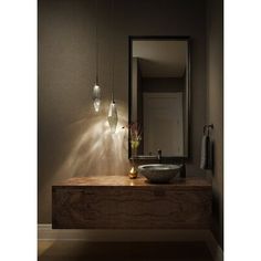 a bathroom sink sitting under a mirror next to a wall mounted faucet with lights on it