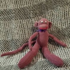 a pink stuffed animal sitting on top of a bed