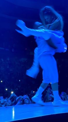 a woman is dancing on the stage in front of an audience