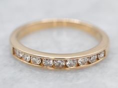 This diamond band has a thin profile that makes it perfect for stacking with other rings! The classic channel setting protects the diamonds while still letting light flow through them. Simple and beautiful, this ring is sure to be a classic for years to come.Metal: 14K Yellow GoldGem: 9 Diamonds totaling .27 Carats, SI in Clarity, G-I in ColorWidth of Band: 2.8 mmHeight off Finger: 1.9 mmRing Size: 5.25Marks: “14K” Stamped on the inside band Gold Wedding Band Women, Classic Channel, Channel Set Diamond Band, Wedding Band Gold, Gold Wedding Bands Women, Channel Setting, Gold Diamond Wedding Band, Yellow Gold Wedding Band, Rose Gold Band