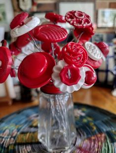 a vase filled with lots of red and white buttons