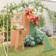 an outdoor party with balloons and decorations in the shape of animals, dinosaurs and trees