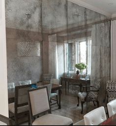 a dining room table and chairs are in front of a glass wall that is reflecting the windows