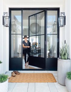 a woman standing in the doorway of a house with her feet on the door mat