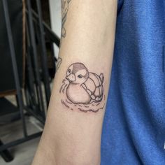 a tattoo on the arm of a person with a bird in it's beak