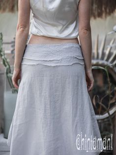 "⫸ We ship by EXPRESS EMS now for fast & safe delivery! Simple, yet very original grey boho linen skirt with our signature asymmetric silhouette. Short on the front and long on the back, this model graciously cascades around you, creating very floaty feeling, especially when you move. It is very easy to put on, as it has zipper on the side, which is secured by a button clasp. Raw, flat belt is decorated with Navajo (American Indian) themed embroidery and open edges. This skirt comes in two a Fitted Bohemian Asymmetrical Skirt, Bohemian Skirt With Asymmetrical Hem, Bohemian Fitted Skirt With Asymmetrical Hem, Bohemian Fitted Wrap Skirt With Asymmetrical Hem, Bohemian Asymmetrical Hem Maxi Skirt, Grey Boho, Organic Clothing Women, Festival Skirt, Festival Skirts