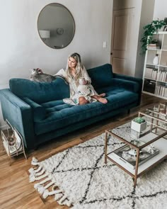 a woman sitting on top of a blue couch