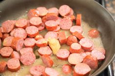 sausage and potatoes cooking in a pan on the stove