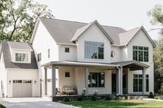 a large white house with lots of windows on it's sides and two car garages