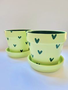 two green bowls with hearts painted on them