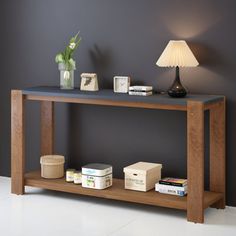 a wooden table with two lamps on it and some books in front of the table