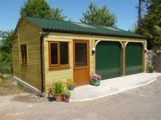 a green garage with two doors and windows