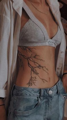 a woman with a tree tattoo on her stomach