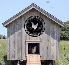 two chickens are standing in the doorway of a chicken coop that is made out of wood