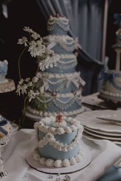 a blue and white cake sitting on top of a table next to other desserts