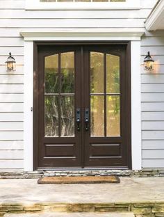 the front door of a house with two lights on each side and one light on top