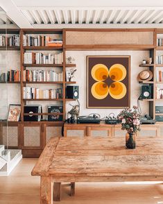 a wooden table sitting in front of a book shelf filled with books