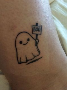 a tattoo with a ghost holding a sign that says boo