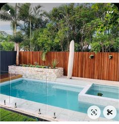 a backyard with a swimming pool and wooden fence