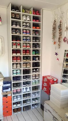 a room filled with lots of shoes and boxes on top of the floor in front of a white wall