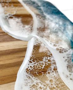 a close up view of a wooden table with white and blue waves on it,