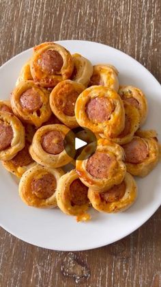 a white plate topped with mini pizzas on top of a wooden table