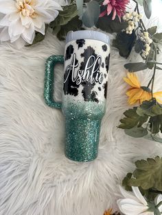 the personalized tumbler is next to flowers on a white furnishing area