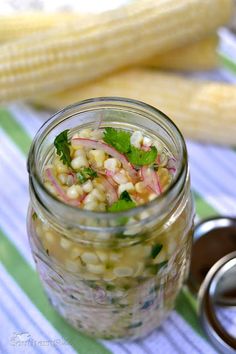 a jar filled with food sitting on top of a table next to a metal spoon