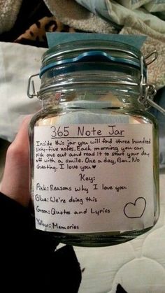 a person holding a jar with writing on it and a note attached to the lid