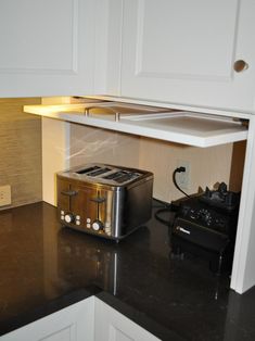 a toaster sitting on top of a black counter next to a microwave and oven