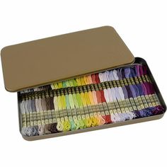 an open tin box filled with different colored thread