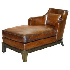 a brown leather chaise lounge chair with wooden legs and foot rest on an isolated white background