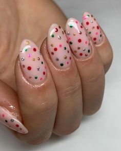 For a joyful holiday vibe, these nails sparkle with rainbow polka dots against a soft pink base. Metallic green, red, and gold dots are mixed with silver glitter accents, creating a playful, confetti-like effect. This nail art design is lively and captures the spirit of the holiday season, making it a fantastic choice for those who love a splash of color and a bit of festive flair. Polka Dot Christmas, Christmas Nail Ideas, Dot Nails, Beauty Hacks Nails, Rainbow Polka Dots, Polka Dot Nails, Dots Nails, Nail Tattoo