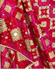 This stunning heavy red bridal dupatta features an intricate phulkari design on chinon silk material. Expertly detailed with sparkling accessories, multicolor silk thread work, mirror work, and sequins, the dupatta is finished with a gold trim along the border. Perfect for pairing with any color lehenga set or salwar suit. Chinon Silk Phulkari embroidery work, mirror work, sequins, accessories Size: Approx. Length 90" Width: 42" Gold trim on border Pattern: Geometric Care: Dry Clean Red Bridal Dupatta, Phulkari Design, Phulkari Suit, Phulkari Embroidery, Bridal Dupatta, Phulkari Dupatta, Textured Leggings, Party Wear Lehenga, Beautiful Suit