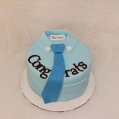 a blue cake with a tie on it that says congrats in black lettering